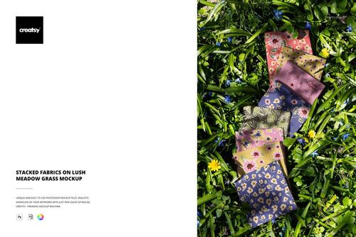 Assorted colorful fabrics featuring floral and geometric designs laid out on lush green grass in a top view mockup.
