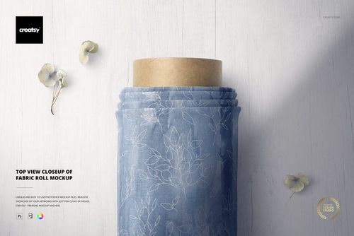 Fabric roll mockup shown from above, featuring a soft blue textile with a delicate leaf design and dried floral accents.