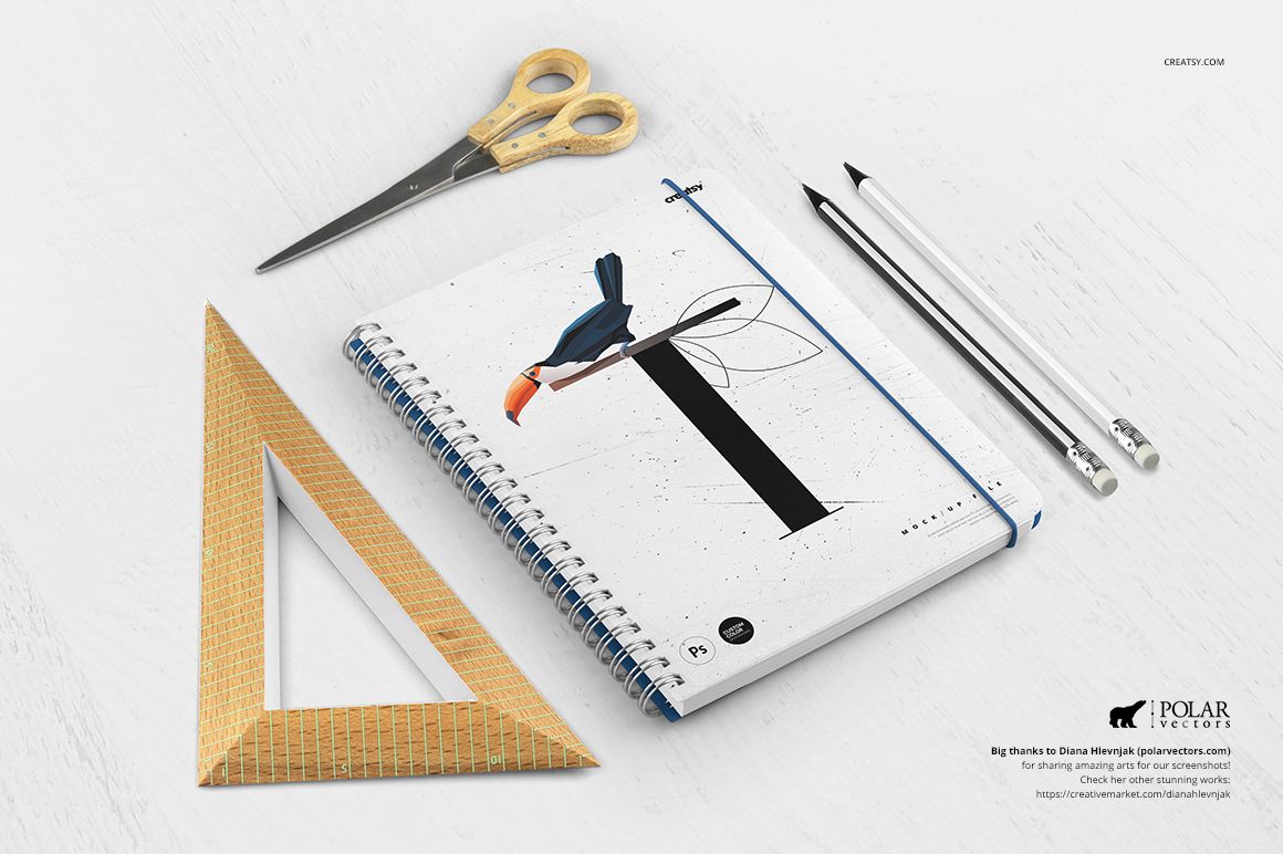 Front view of a spiral notebook mockup featuring a bird design, surrounded by stationery items on a white desk.