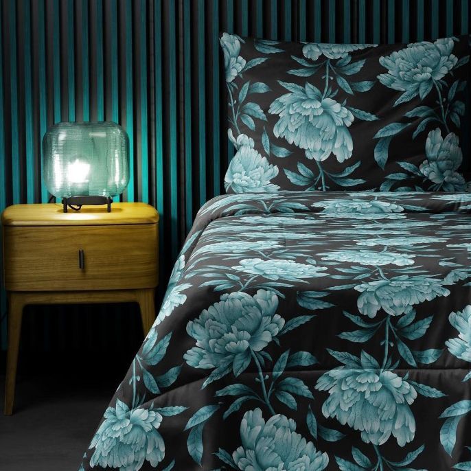 Microfiber comforter mockup featuring a large blue peony floral pattern on a dark background, styled on a bed with a matching pillow.