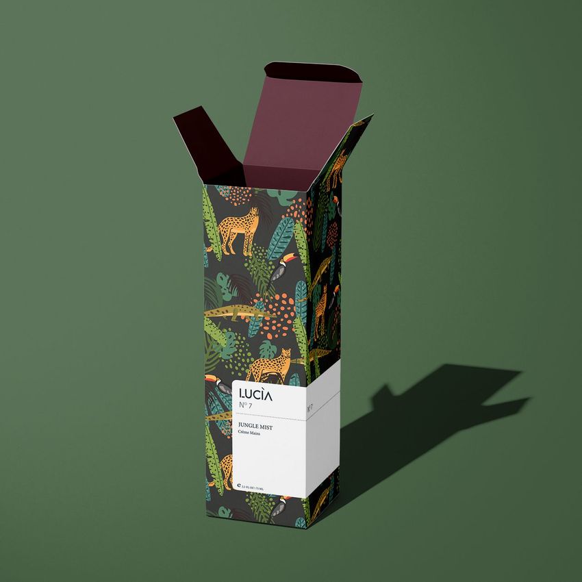 Tall box mockup with jungle-themed pattern, featuring illustrated foliage and animals on a green background, photographed at an angle.