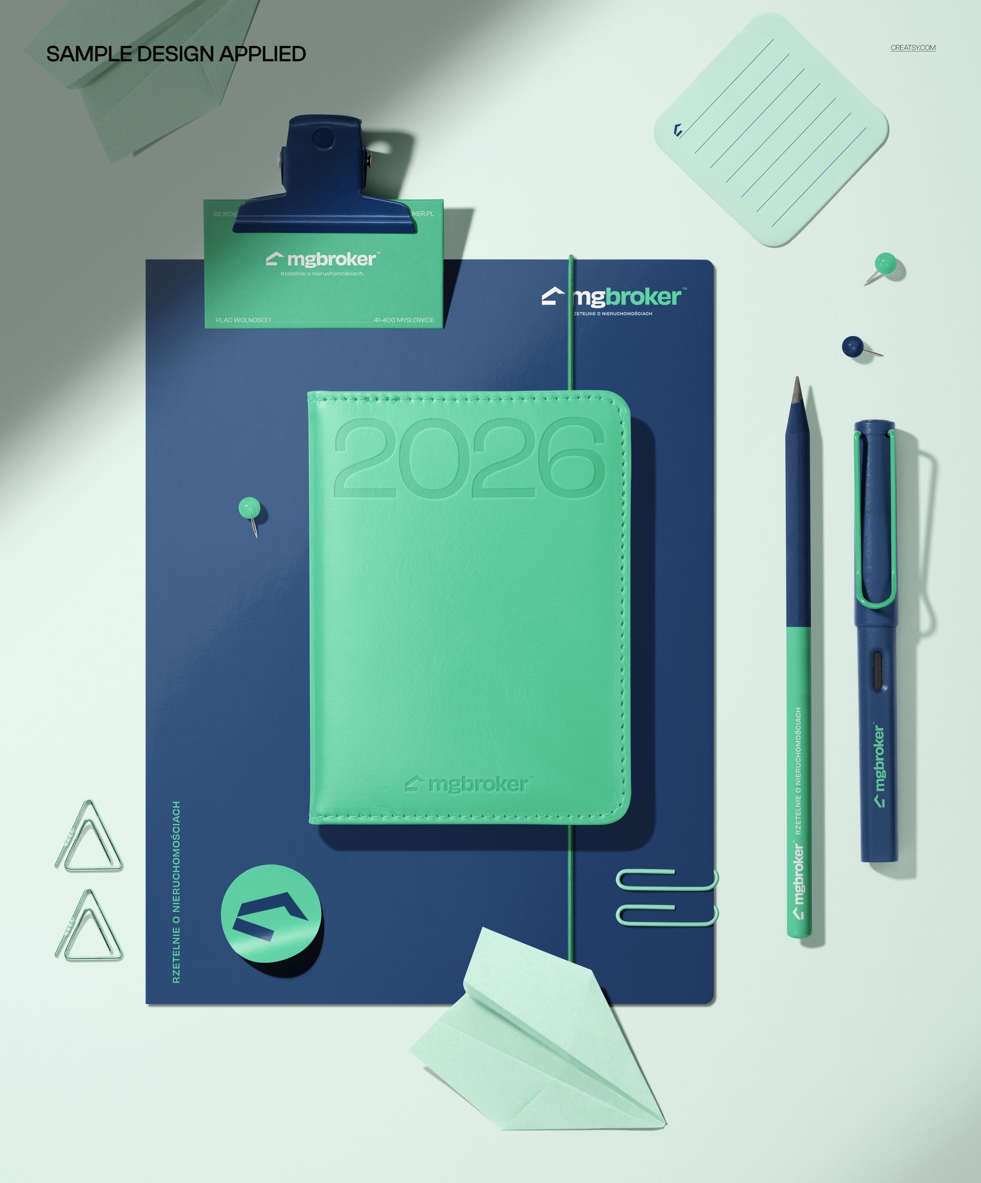 Overhead view of a leather calendar, folder, business card, pen, pencil, clips, sticky notes, and sticker in a stationery mockup.
