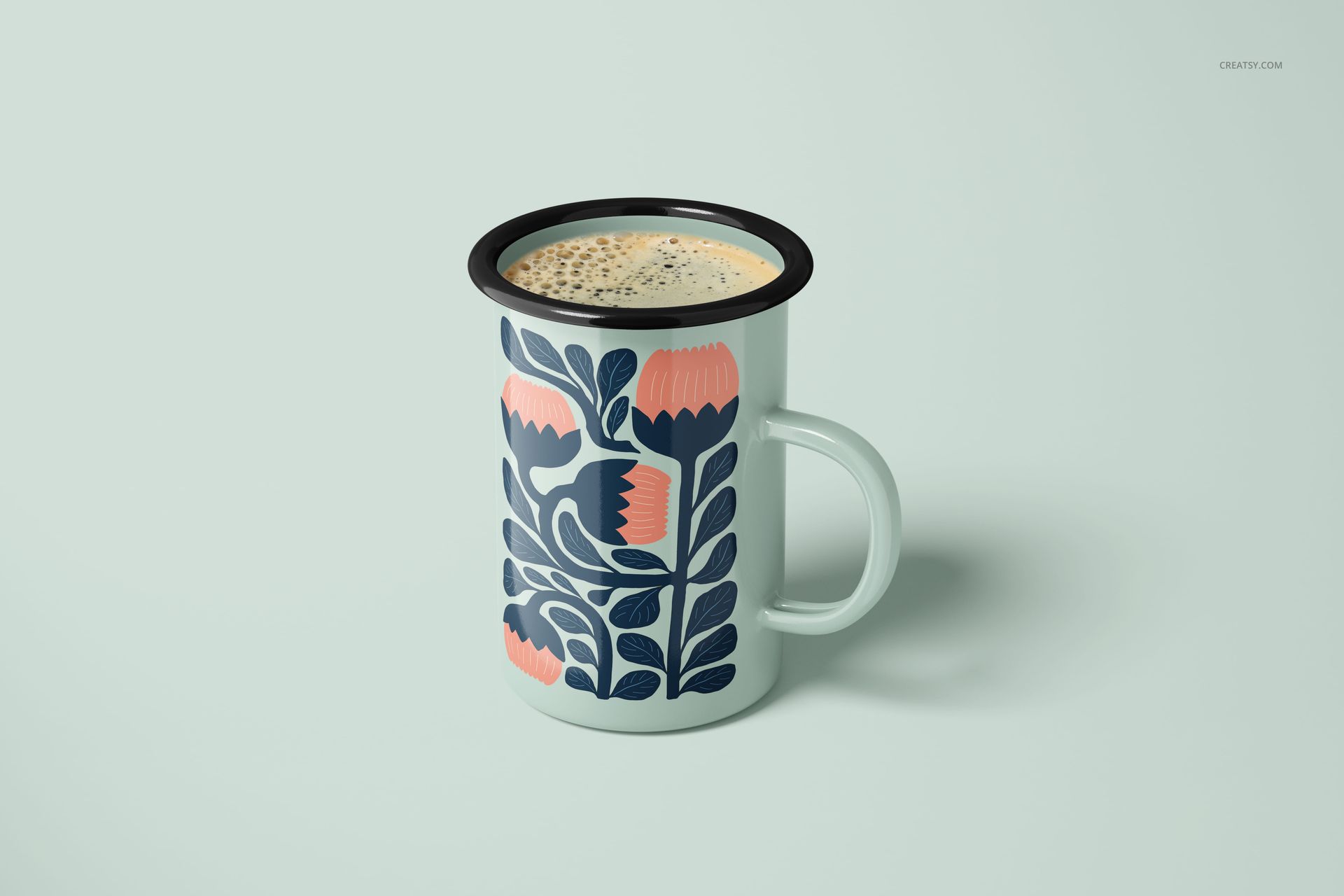450ml enamel mug mockup with a botanical design in dark blue and coral, displayed on a pale surface.