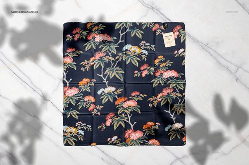 Silk scarf mockup featuring a botanical design with colorful flowers and leaves, displayed flat on a marble backdrop.