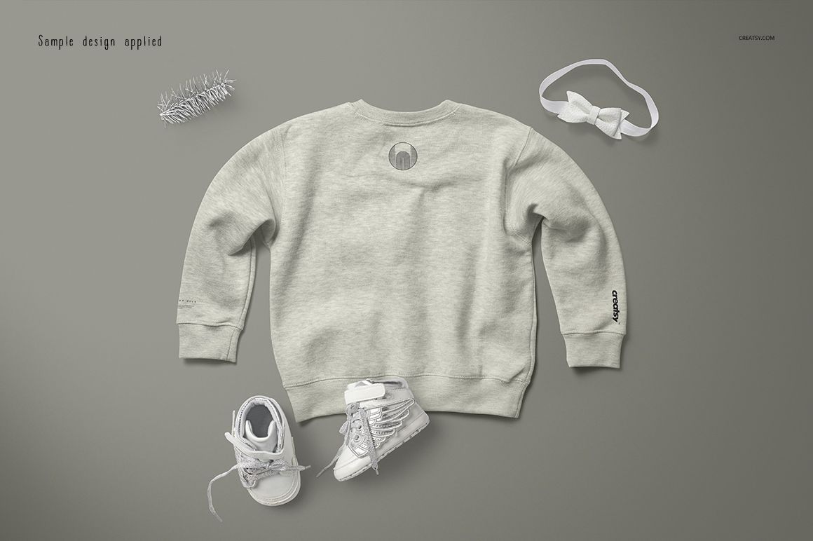 PSD mockup of a heather baby sweatshirt shown from the back, surrounded by white baby shoes and a bow headband.