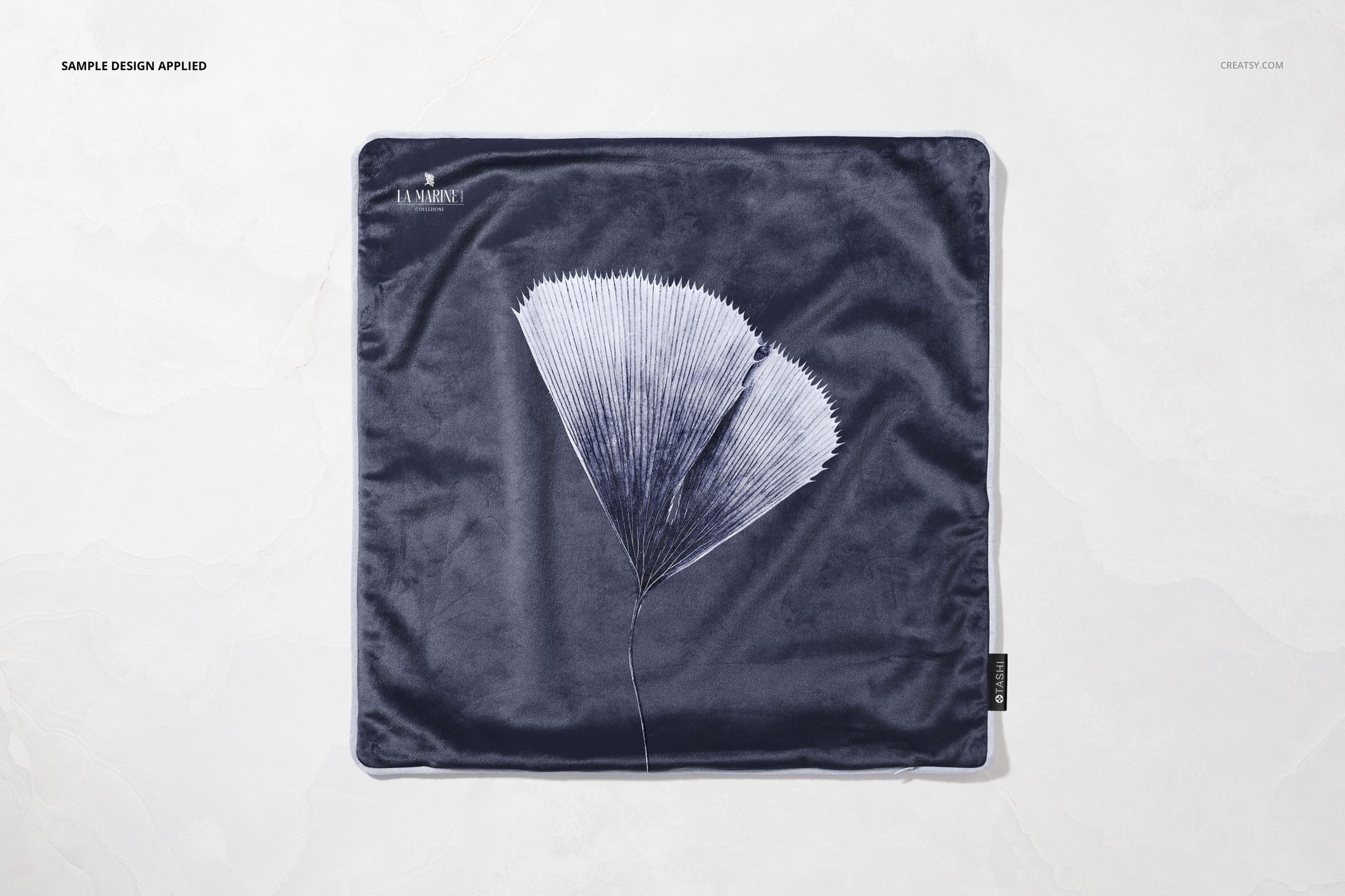 Square velvet pillow mockup featuring a navy blue color and a white botanical pattern, viewed from above.