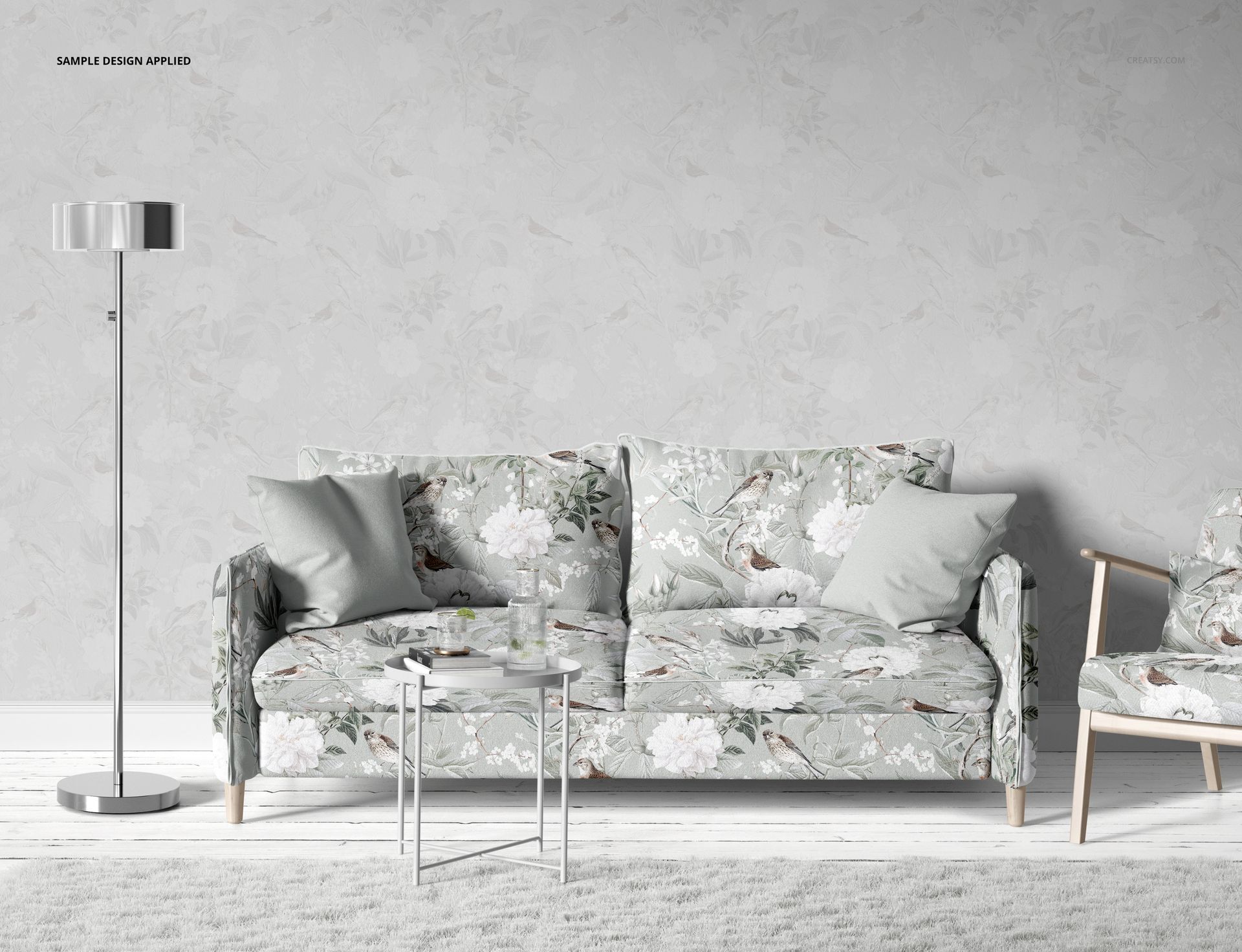 Living room mockup featuring a sofa and armchair with soft-toned floral pillows, light wallpaper, and modern decor.