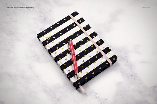 Striped planner mockup with gold accents and elastic band, displayed on a light marble background with a red pen.