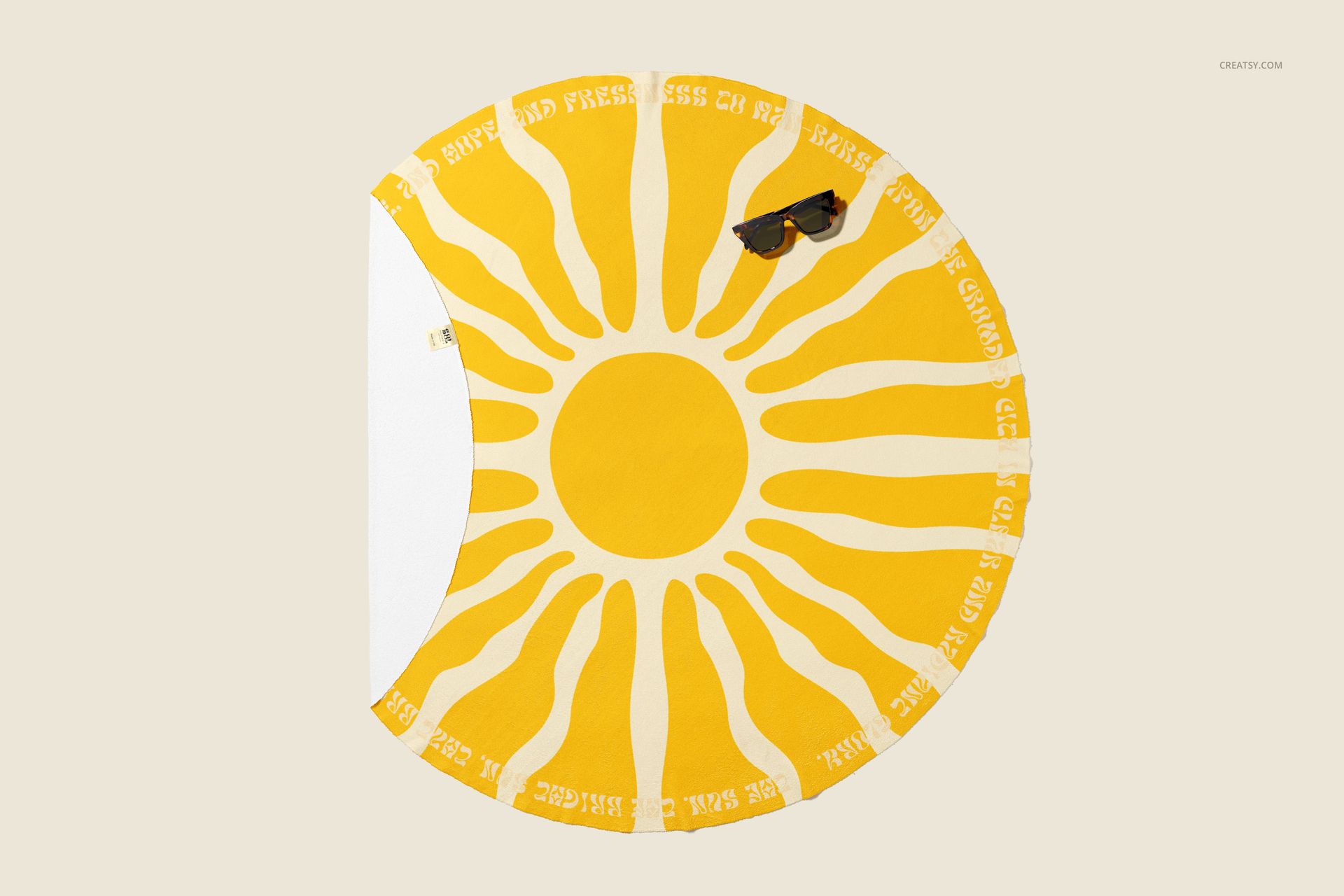 Microfiber round beach towel mockup featuring a bold yellow sun design and white accents, displayed flat overhead.