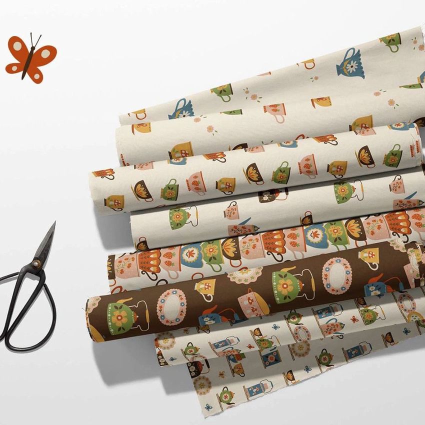 Fabric rolls mockup featuring retro kitchen-themed patterns in various colors, arranged on a light surface with scissors nearby.