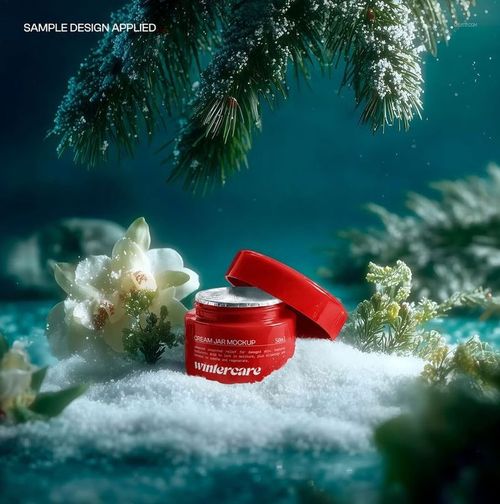 Plastic cream jar with red lid displayed in snow, surrounded by winter greenery and flowers, front view mockup.