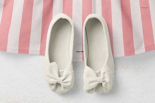 Top view of a baby dress mockup with a pink and white striped skirt and a pair of cream-colored shoes with bows.