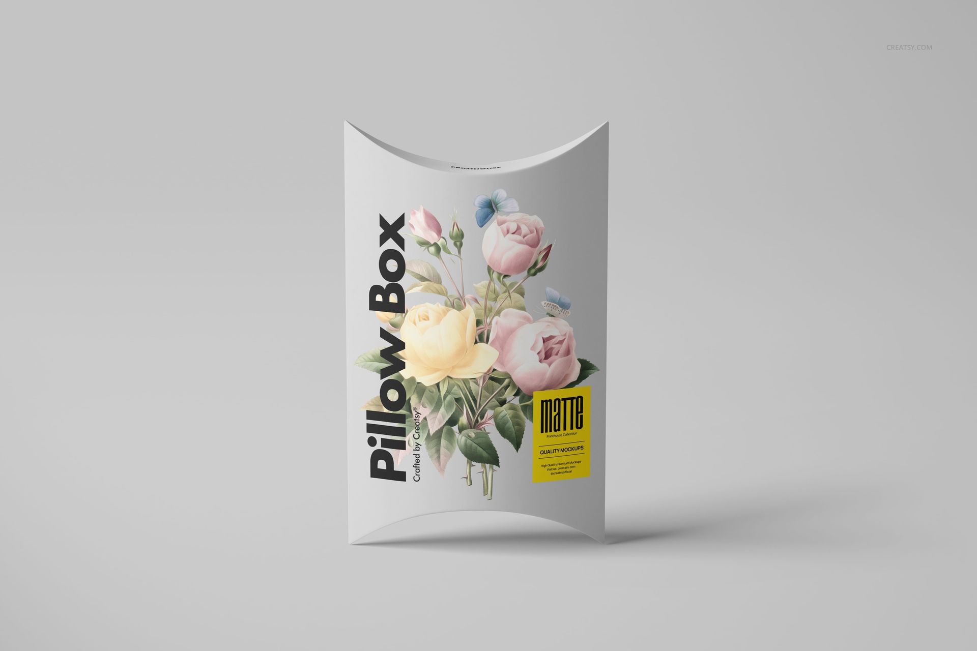 Front view of a matte pillow box mockup displaying soft-colored flowers and modern typography on a light surface.
