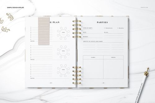 Top view of an open planner mockup showing organized tables, guest lists, and a gold pen on a white marble background.