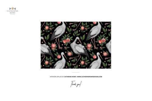 Rectangular mockup scene showing a repeating crane and floral pattern on a dark background, viewed from above.