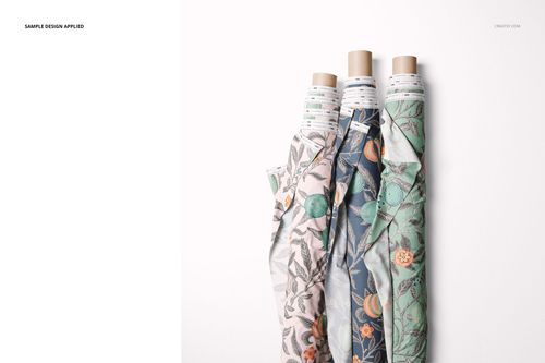 PSD mockup of three patterned fabric rolls with botanical motifs in muted colors, displayed against a white background.