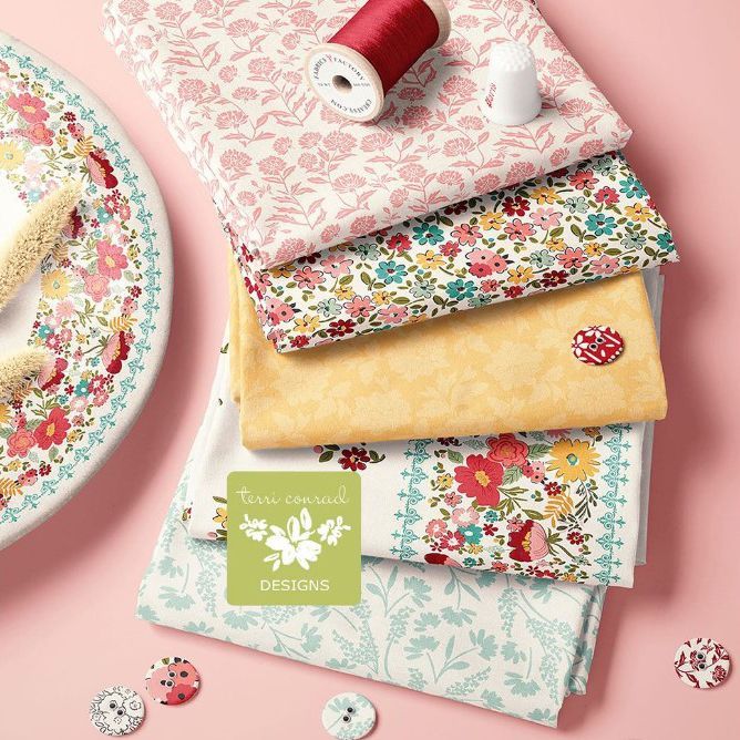 Fabric stack mockup showing five folded fabrics with floral patterns in pink, yellow, white, and multicolor on a pink background.