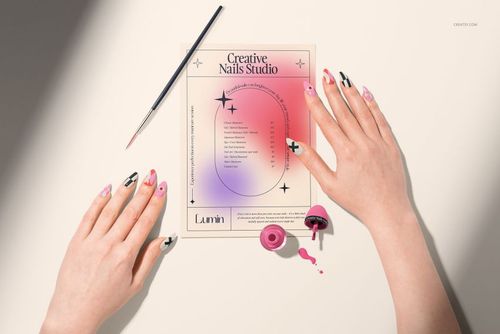 PSD mockup featuring hands with creative nail designs, a gradient sheet, nail polish, and brush in a beauty scene.