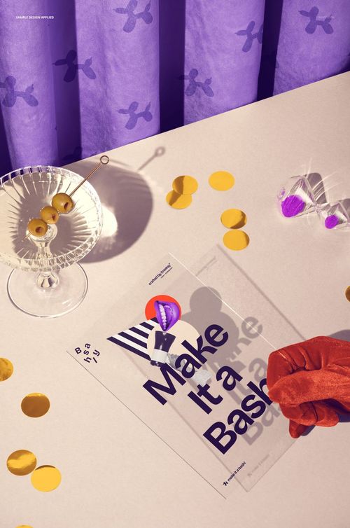 Clear card PSD mockup on a white table with gold confetti, olives in a glass dish, and purple party decorations.