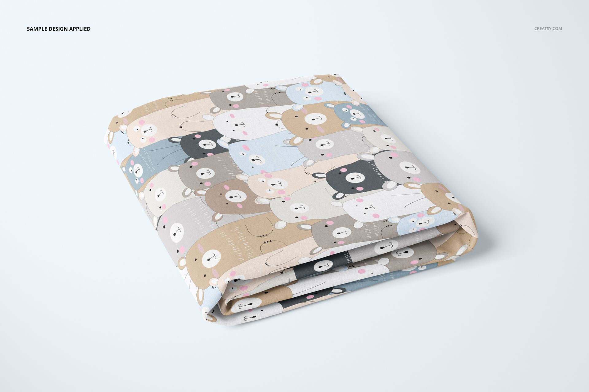 Crib sheet mockup with a cute bear design in beige, blue, and gray tones, displayed folded on a light background.