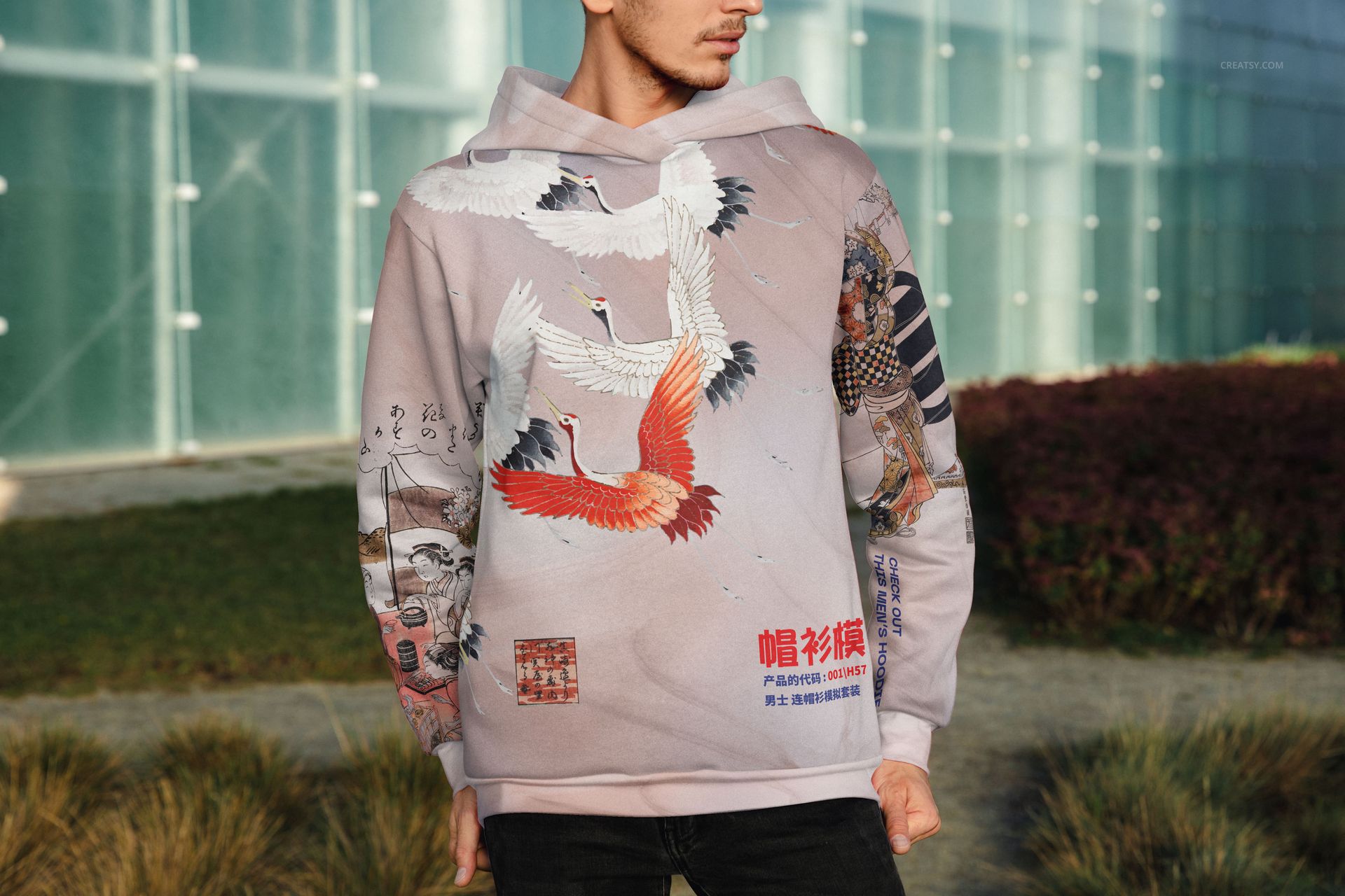 PSD mockup of a men's oversized hoodie with colorful crane illustrations, shown from the front in an outdoor setting.