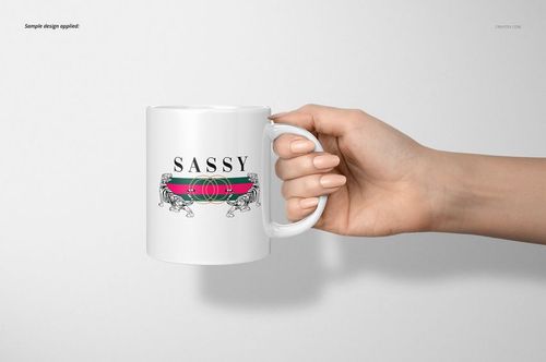 Hand holding a white 11oz mug with a colorful stripe and illustrated design, viewed from the side against a light background.