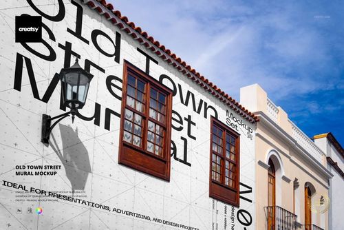 Old Town street mural PSD mockup showing a white facade with bold black lettering, wooden framed windows, and lamp.
