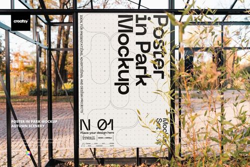 Outdoor PSD mockup showing a rectangular poster on a black frame, with autumn foliage and paved walkway in view.