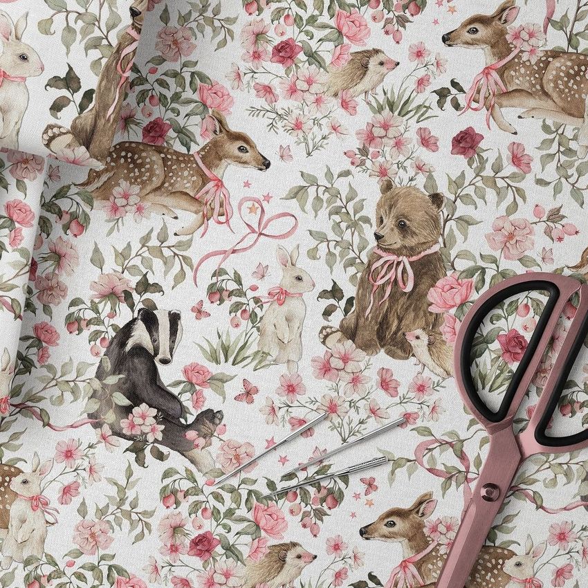 Folded fabric mockup featuring a woodland animal pattern with deer, bears, rabbits, and pink floral accents on a light background.